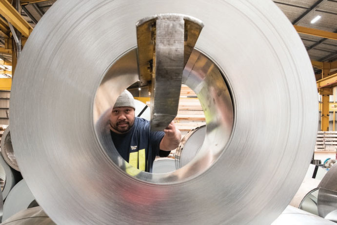 A man working with a sheet of steel